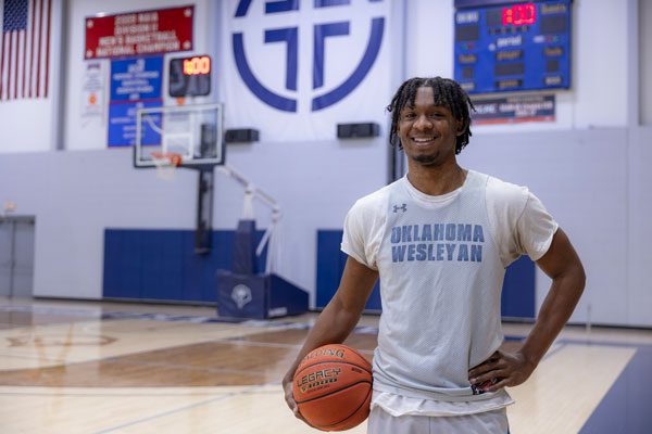 Student standing with basketball in the MSC Gym