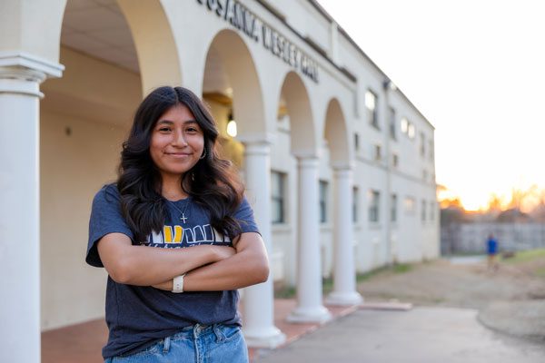 Student standing in front of Wesley Hall