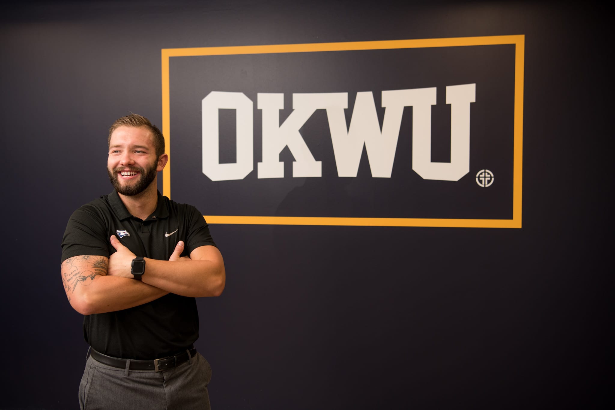 Jake Feickert standing next to the large OKWU mural