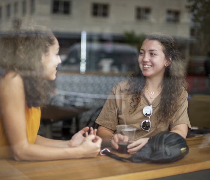 two women inside coffee shop window