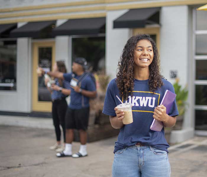 student smiling outside coffee shop