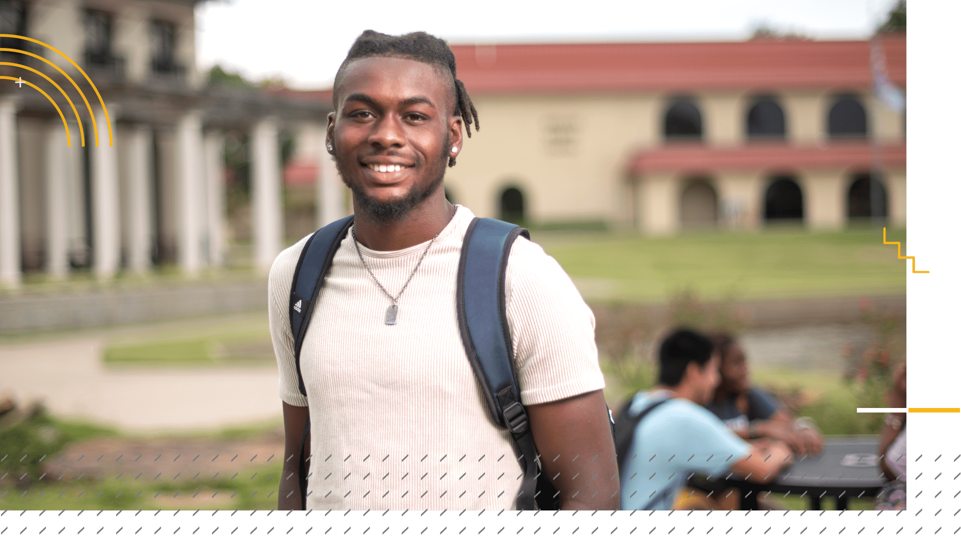 student smiling in front of sports center and library