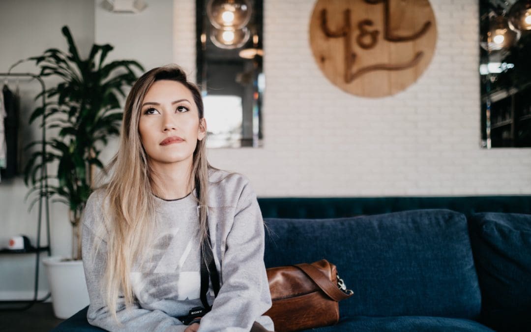 young-woman-sitting-staring-up-thinking