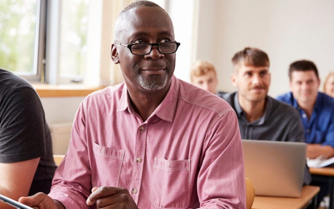 students in classroom focused on middle age black man