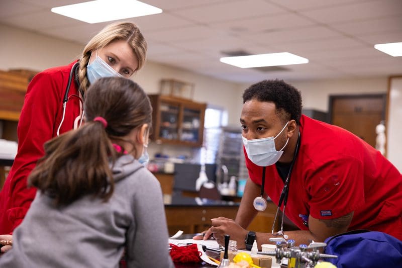Two nursing students assess patient as part of the OKWU nursing program