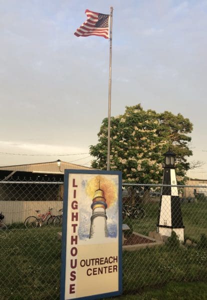lighthouse sign with American flag