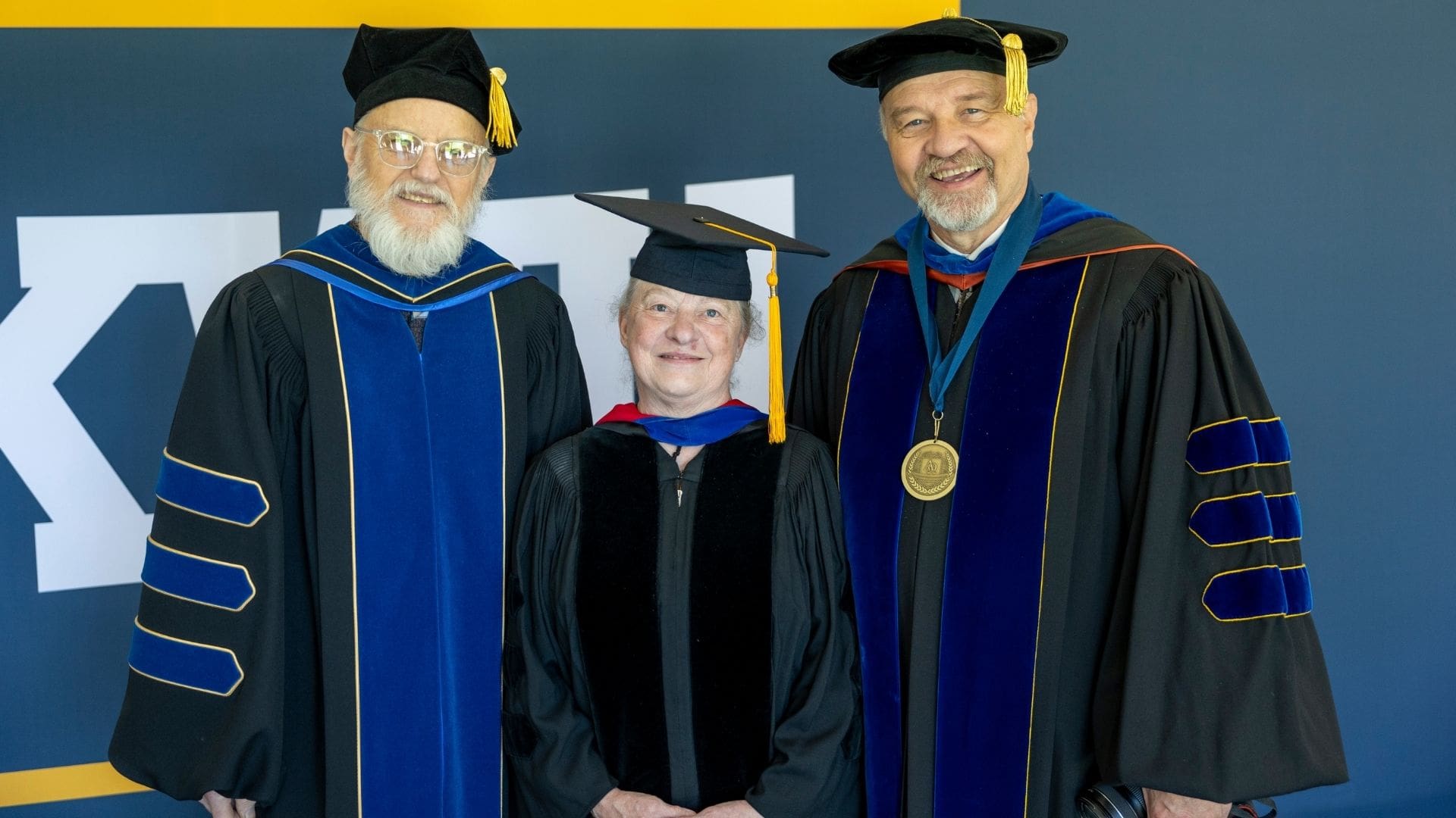 Professors in front of sign
