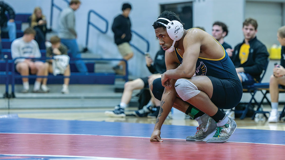 News 10 OKWU Wrestling student crouches down, focused look on his face